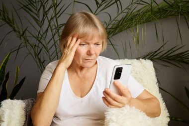 Mutsuz son sınıf öğrencisi bir kadın evde oturup telefonuna rahatsız edici bir ifadeyle bakınıyor. İnternet içeriğinde geziyor, cep telefonu kullanıyor ve sosyal medyada üzgün ve üzgün bir şekilde mesajlaşıyor.