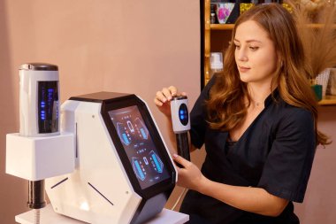 Güzellik uzmanı, modern bir salonda müşterilere etkili cilt bakımı sağlayan yüksek teknolojili bir cilt bakımı cihazı kullanıyor..