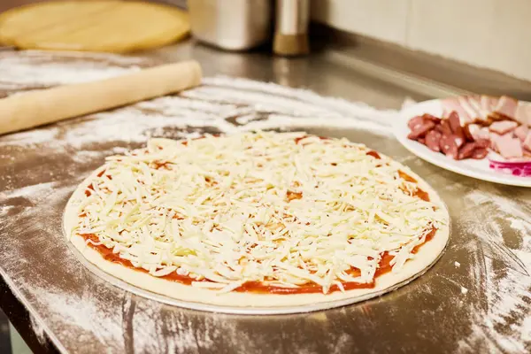 Hamur, un kaplı bir tezgahın üzerine yuvarlanır ve yanında malzemelerle dolu bir tabak bulunur. Mutfak sıcak ve davetkar. Lezzetli bir yemek yapmak için mükemmel..