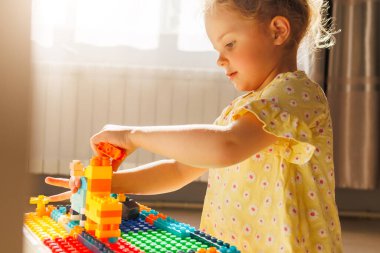 Küçük çocuk renkli inşaat blokları olan bir masaya odaklanmıştı. Yaratıcı eğlence ve öğrenme etkinliği.