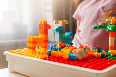 Renkli oyuncak hayvanlar ve yapı taşları temel plaka üzerine inşa edilmiş yapılar. Yaratıcı çocukluk oyunu.