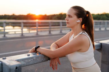 Genç bir kadın gün batımında huzurlu bir anın tadını çıkarıyor. Köprüde dinleniyor. Güneş nehrin üzerinde batarken müzik dinliyor..