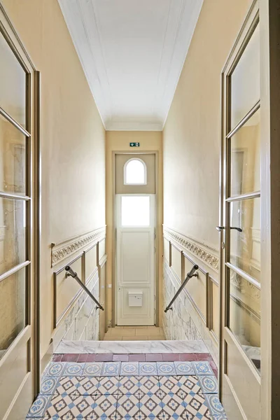Entrance door and Marble stairs in renovated mansion stairwell