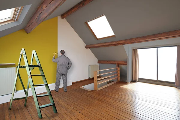 Pintor Pintando Uma Parede Amarela Sótão Interior Renovado — Fotografia de Stock