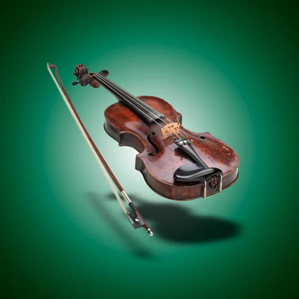 緑のグラデーションの背景に影を持つ浮動クラシックバイオリン楽器 — ストック写真