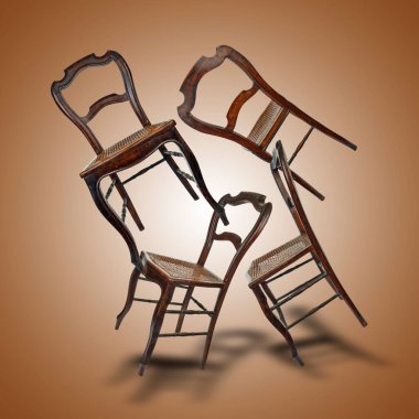 Kahverengi arka planda gölgeleri olan tahta sandalyeler.