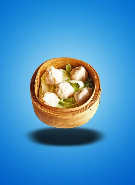 Floating Bamboo basket with five cooked Dim Sum on blue gradient background