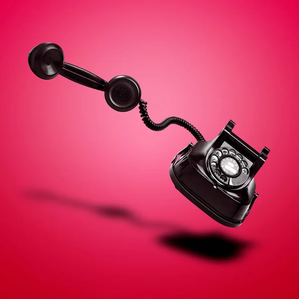 Плавающий Черный Телефон Тенью Красном Радиальном Фоне — стоковое фото