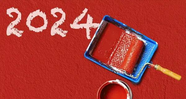 红色墙上的绘画工具和2024年的文字 新年快乐A 图库图片