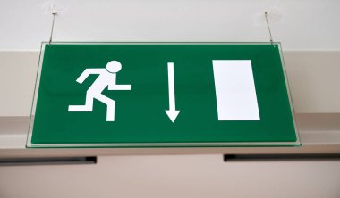 Yeşil acil durum işareti doğru yönü gösteriyor.