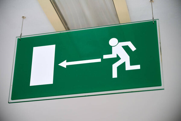 Green emergency sign indicate the right direction hanging
