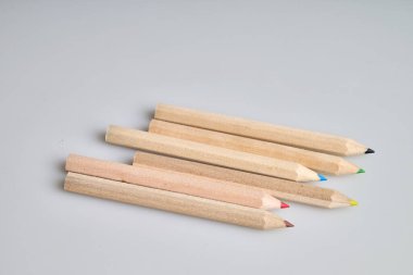 Beyaz arka planda altı çiğ tahta kalem.