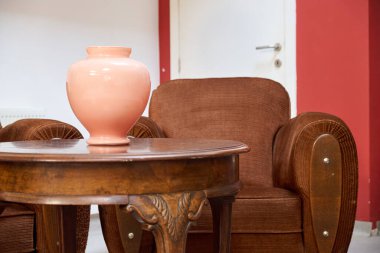 Eski moda masası ve beyaz duvarlı kanepesi olan rahat bir çatı katı.