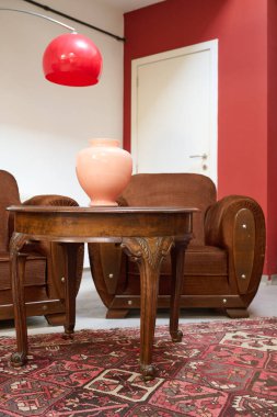 Eski moda masası ve beyaz duvarlı kanepesi olan rahat bir çatı katı.