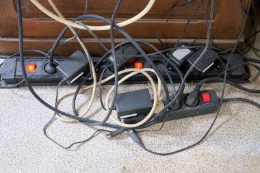 Ahşap masanın yanında bir sürü dağınık kablo var.