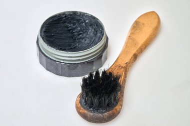 Siyah ayakkabı boyası ve beyaz arka planda kirli fırça.