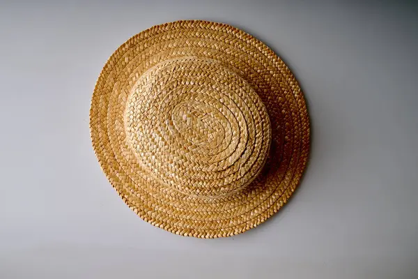 Yukarıdan beyaz arkaplan görünümlü sarı hasır şapka