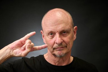 Stüdyoda yaşlı bir adamın klasik bir Harcourt tarzı ışıklandırmayla mükemmel tabelasını çizerken yakın plan portresi.