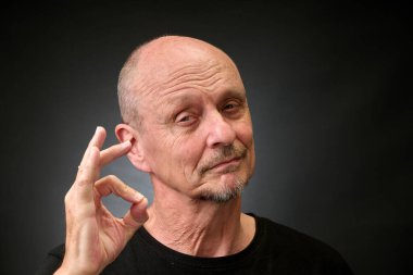 Stüdyoda yaşlı bir adamın klasik bir Harcourt tarzı ışıklandırmayla mükemmel tabelasını çizerken yakın plan portresi.