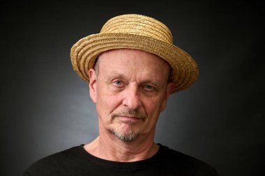 Eski Harcourt tarzı ışıklandırmalı hasır şapkalı üzgün bir son sınıf öğrencisinin yakın plan portresi.