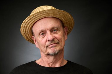 Eski Harcourt tarzı ışıklandırmalı hasır şapkalı üzgün bir son sınıf öğrencisinin yakın plan portresi.