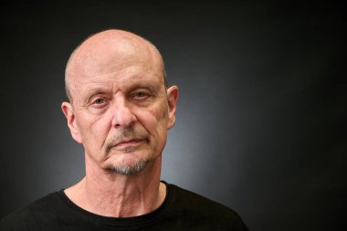 Eski bir Harcourt tarzı ışıklandırmada üst düzey bir adamın yakın plan portresi.