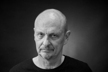 Klasik Harcourt tarzı ışıklandırmalı son sınıf öğrencisinin monokrom kapanış portresi.