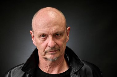 Eski bir Harcourt tarzı ışıklandırmada üst düzey bir adamın yakın plan portresi.