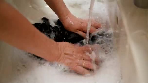 Женские Руки Стирают Черную Одежду Раковине Ванной Комнаты Мылом Баре — стоковое видео