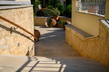 Çiçekleri ve büyük kavanozları olan güzel, gür bir bahçeye çıkan taş bir merdiven. Lüks Afrodit Tepeleri Otel ve Resort binası. Güzel bahçeleri, büyük havuzu ve zarif evi var. Kıbrıs 'ta Paphos.