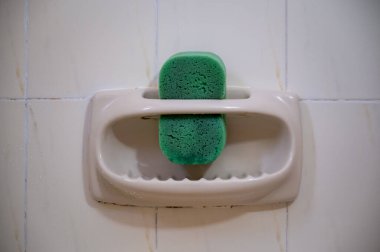 Banyoda yeşil bir süngerle sabun tabağı.