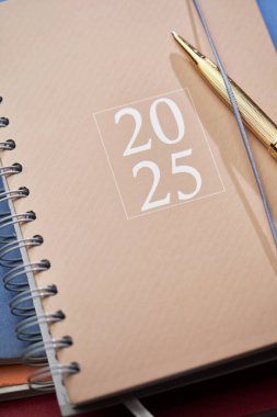 2025 kahverengi günlük dosya yığınının üstünde