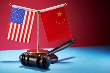 Arka planda ABD bayrağı ve Çin bayrağı bulunan tokmak çekici.