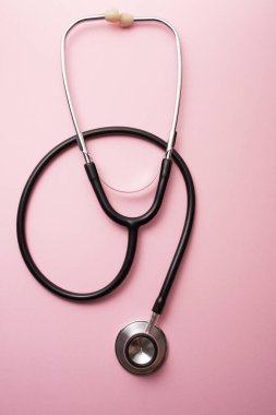 Pembe arka plana karşı siyah steteskop