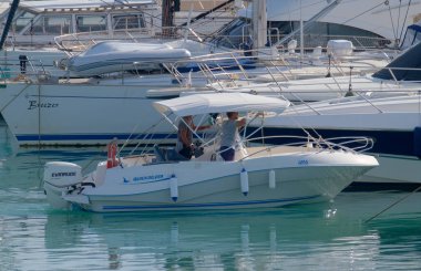 İtalya, Sicilya, Akdeniz, Marina di Ragusa (Ragusa ili); 26 Ekim 2022, limanda bir motorlu tekne ve lüks yatlarda erkekler - EDITORIAL