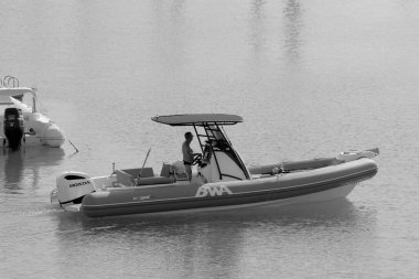 İtalya, Sicilya, Akdeniz, Marina di Ragusa (Ragusa Eyaleti); 28 Ekim 2022, limandaki lastik bir teknede balıkçı - EDITORIAL