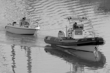 İtalya, Sicilya, Akdeniz, Marina di Ragusa (Ragusa Eyaleti); 28 Ekim 2022, limandaki motorlu teknelerde erkekler - EDITORIAL