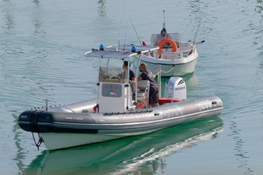 İtalya, Sicilya, Akdeniz, Marina di Ragusa (Ragusa Eyaleti); 28 Ekim 2022, limandaki motorlu teknelerde erkekler - EDITORIAL