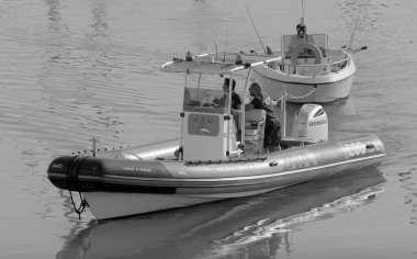 İtalya, Sicilya, Akdeniz, Marina di Ragusa (Ragusa Eyaleti); 28 Ekim 2022, limandaki motorlu teknelerde erkekler - EDITORIAL