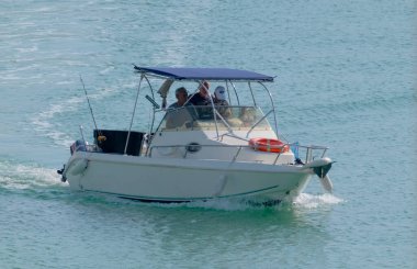 İtalya, Sicilya, Akdeniz, Marina di Ragusa (Ragusa Eyaleti); 29 Ekim 2022, limandaki bir motorlu teknede balıkçı - EDITORIAL