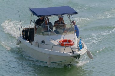 İtalya, Sicilya, Akdeniz, Marina di Ragusa (Ragusa Eyaleti); 29 Ekim 2022, limandaki bir motorlu teknede balıkçı - EDITORIAL