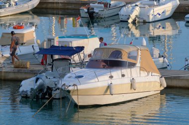 İtalya, Sicilya, Akdeniz, Marina di Ragusa (Ragusa Eyaleti); 30 Ekim 2022, limandaki insanlar, motorlu tekneler ve lüks yatlar - EDITORIAL