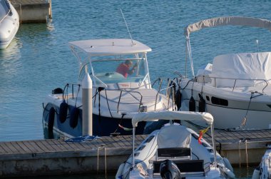 İtalya, Sicilya, Akdeniz, Marina di Ragusa (Ragusa Eyaleti); 31 Ekim 2022, limanda lüks bir yatta adam - EDITORIAL