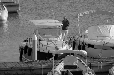 İtalya, Sicilya, Akdeniz, Marina di Ragusa (Ragusa Eyaleti); 31 Ekim 2022, limanda lüks bir yatta adam - EDITORIAL