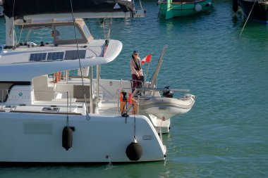 İtalya, Sicilya, Akdeniz, Marina di Ragusa (Ragusa ili); 3 Kasım 2022, limandaki bir yelkenli teknesinde çift - EDITORIAL