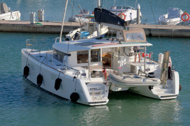 İtalya, Sicilya, Akdeniz, Marina di Ragusa (Ragusa ili); 3 Kasım 2022, limandaki bir yelkenli teknesinde çift - EDITORIAL