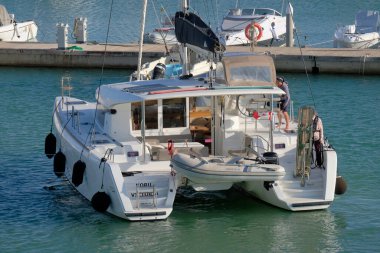 İtalya, Sicilya, Akdeniz, Marina di Ragusa (Ragusa ili); 3 Kasım 2022, limandaki bir yelkenli teknesinde çift - EDITORIAL