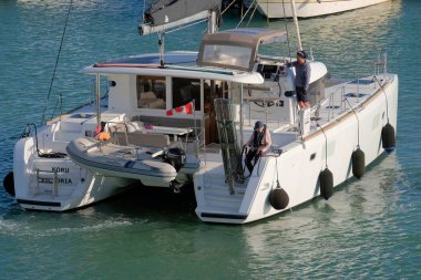 İtalya, Sicilya, Akdeniz, Marina di Ragusa (Ragusa ili); 3 Kasım 2022, limandaki bir yelkenli teknesinde çift - EDITORIAL