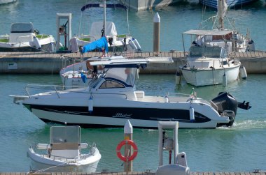 İtalya, Sicilya, Akdeniz, Marina di Ragusa (Ragusa Eyaleti); 4 Kasım 2022, limandaki bir motorlu teknede adam - EDITORIAL