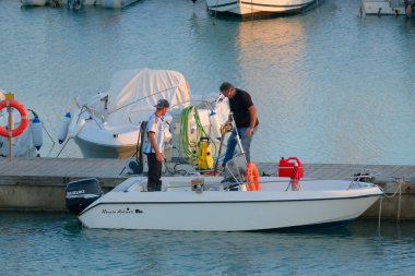 İtalya, Sicilya, Akdeniz, Marina di Ragusa (Ragusa Eyaleti); 3 Kasım 2022, gün batımında limanda insanlar, motorlu tekneler ve lüks yatlar - EDITORIAL